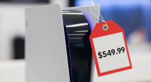 A Sony PlayStation 5 console on a table with a large red tag showing a price increase from $499.99 to $549.99
